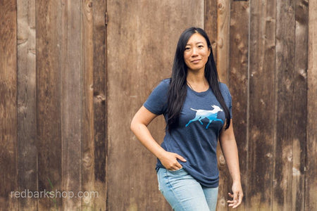Asian Woman modelling a navy shirt with a dog and mountains
